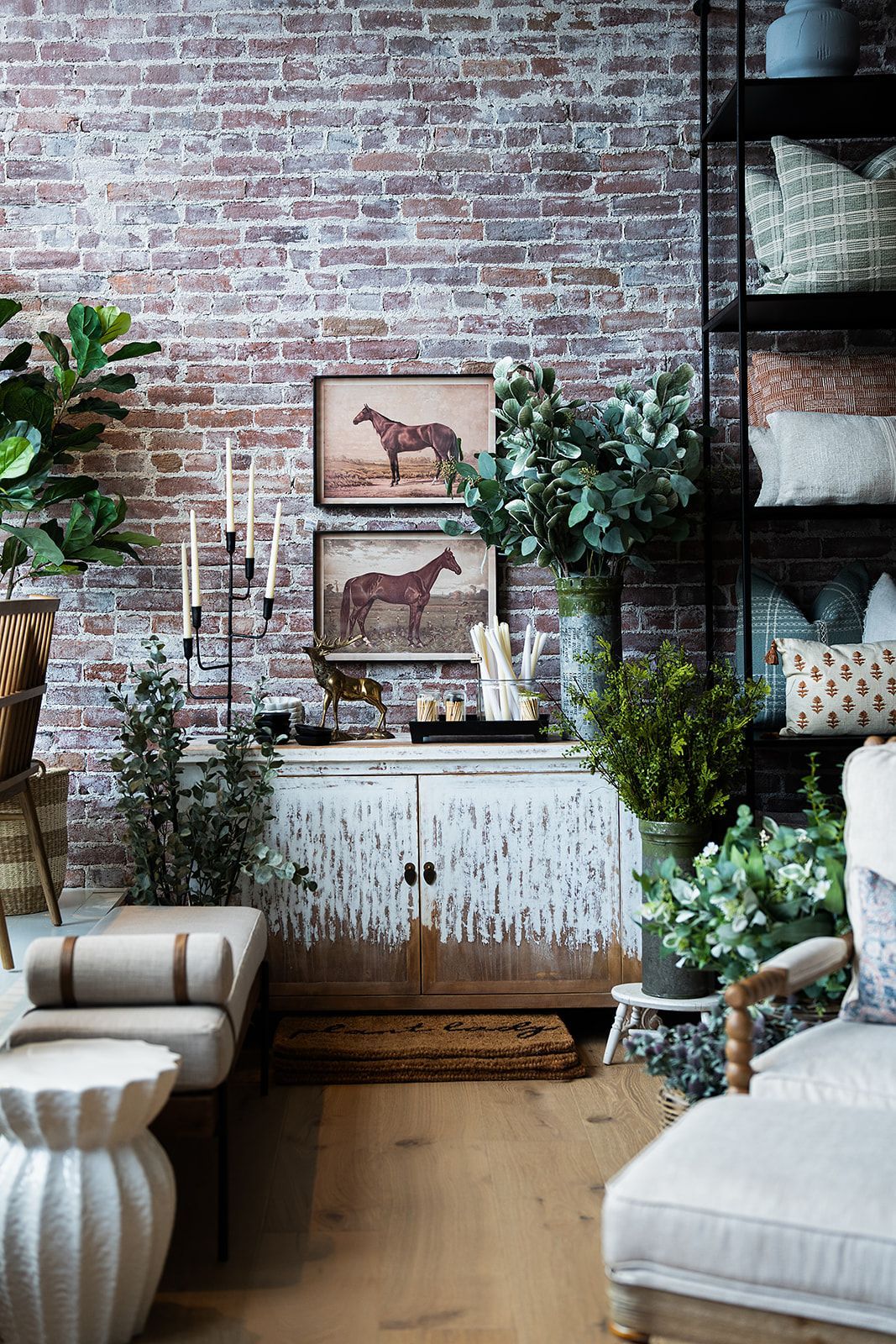 A living room with a brick wall and a white cabinet.