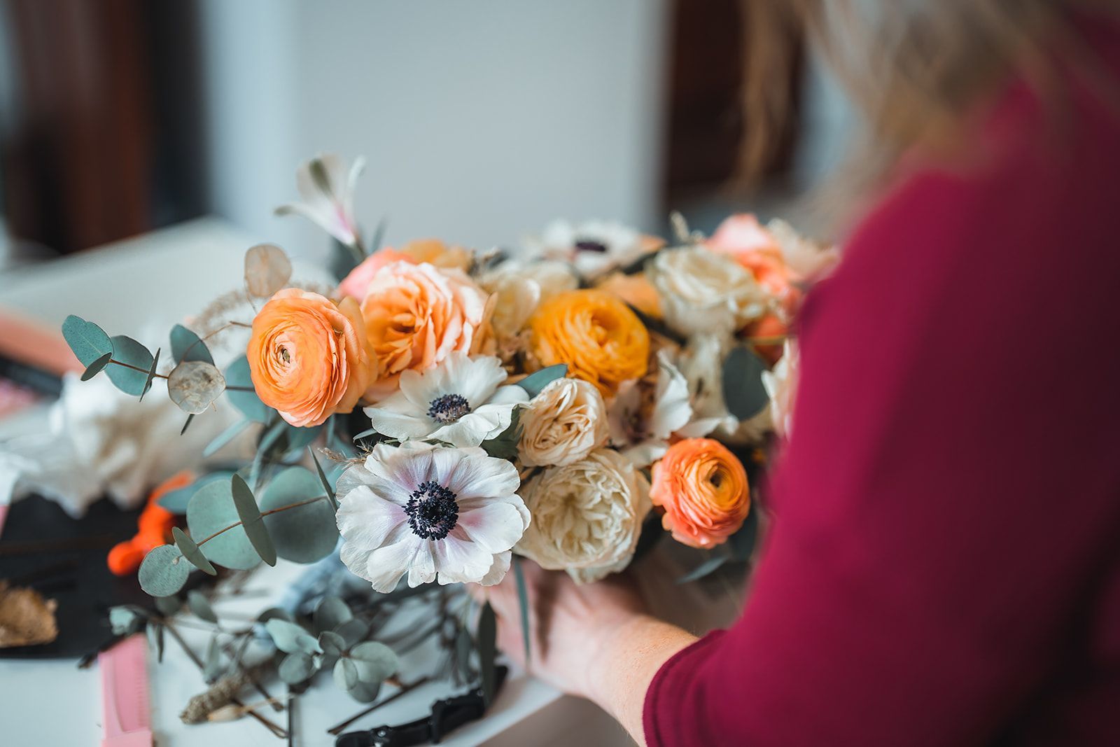 A woman is holding a bouquet of flowers in her hands.