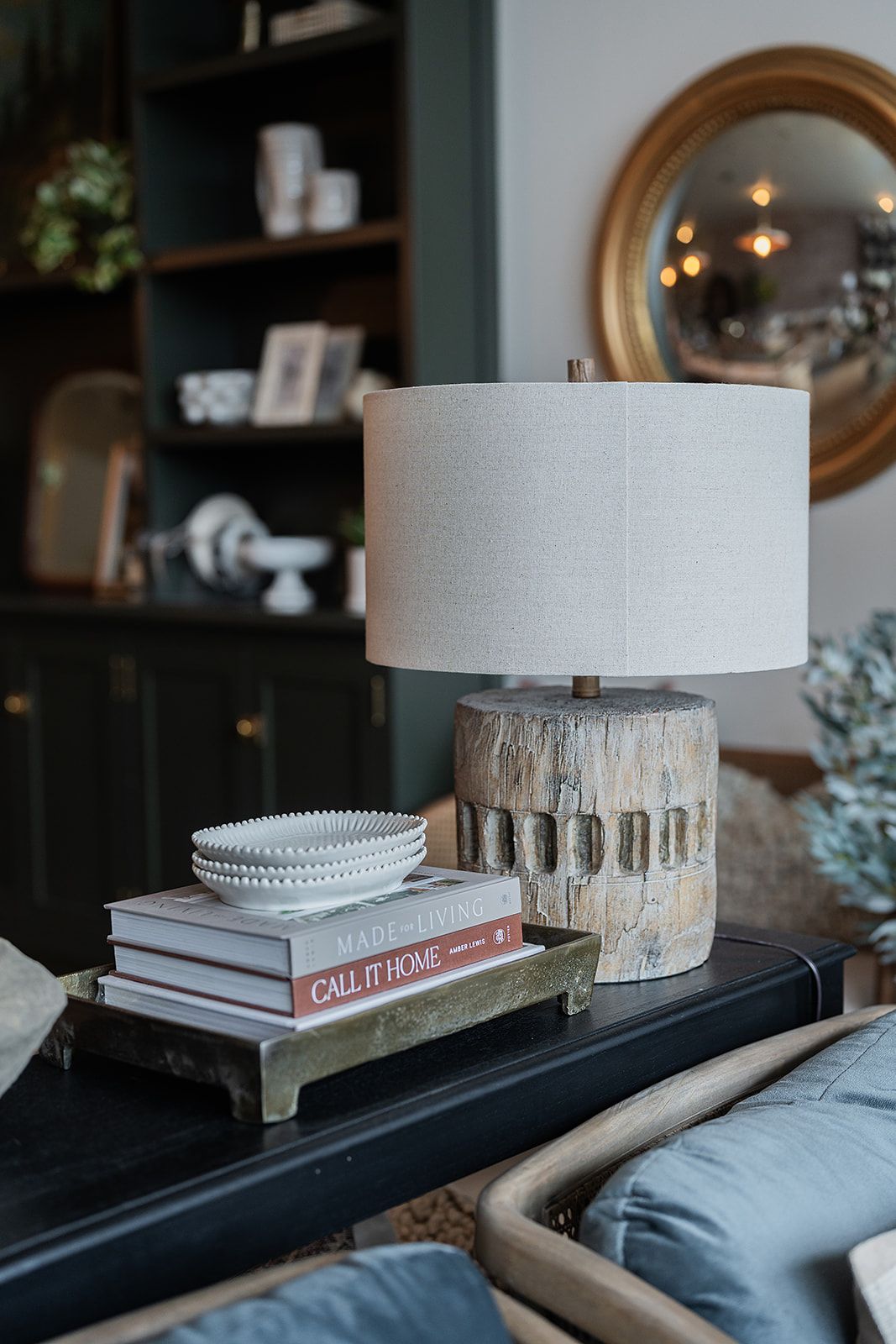 A lamp is sitting on a table next to a stack of books.
