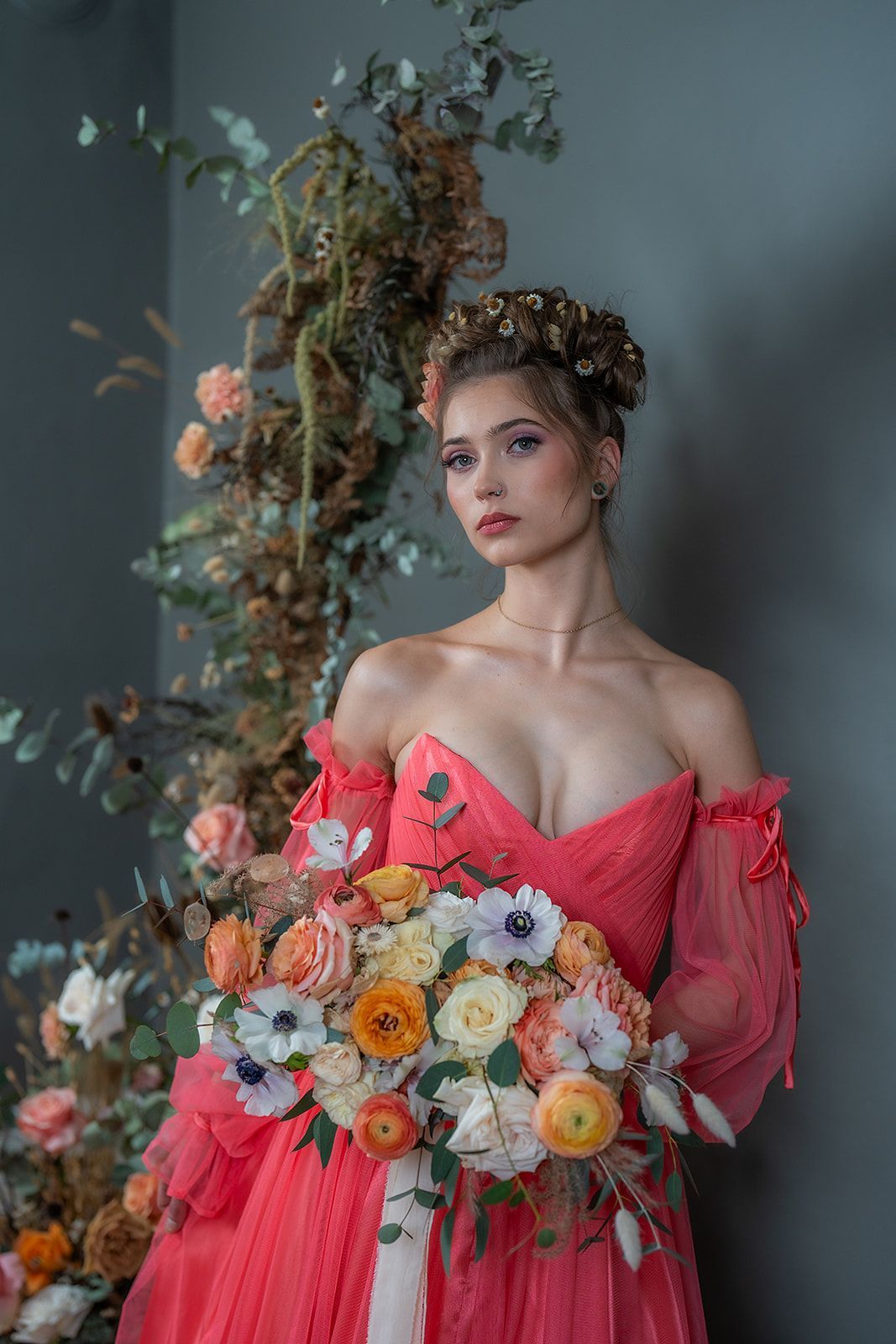 A woman in a red dress is holding a bouquet of flowers.