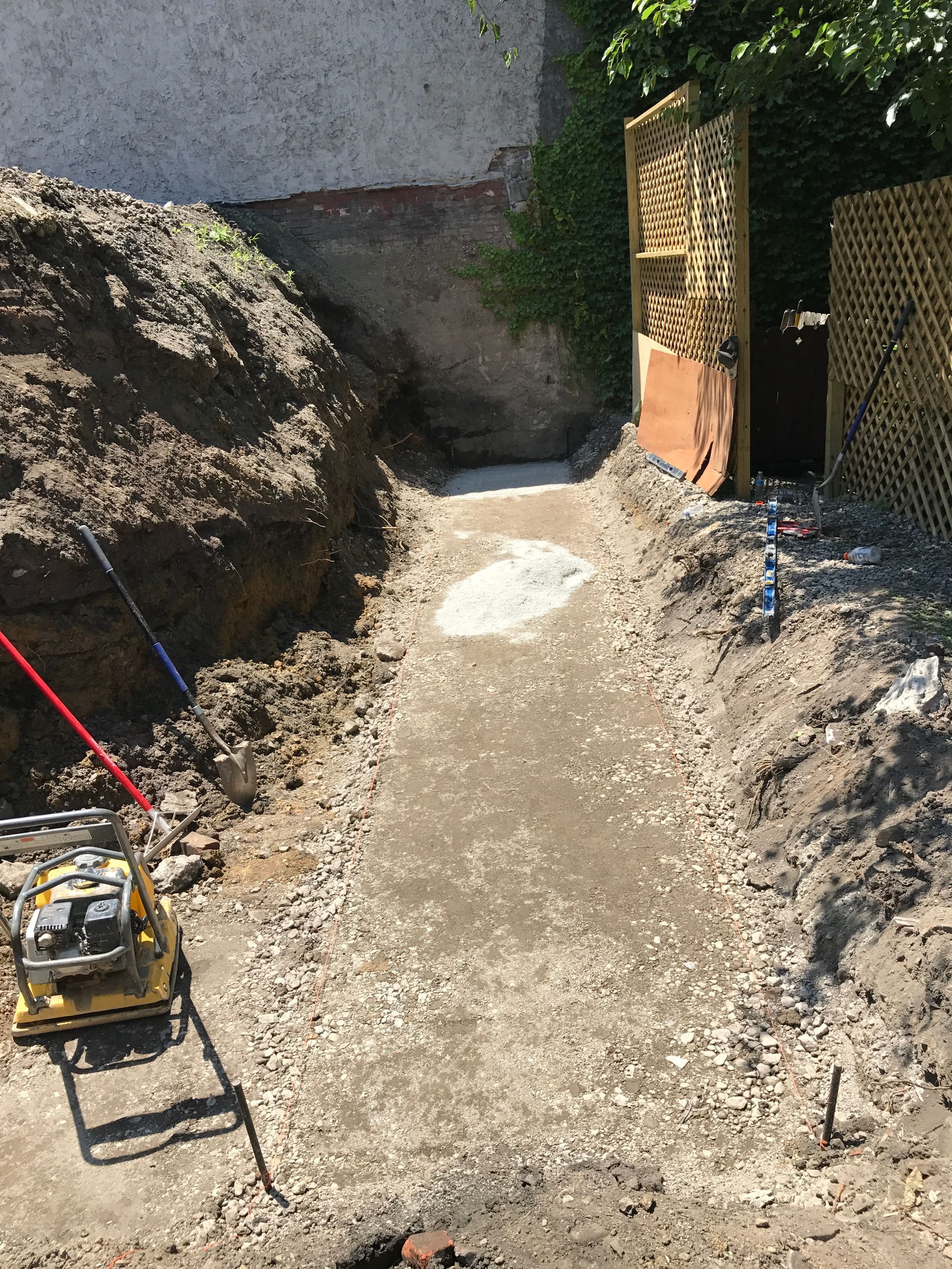 A concrete walkway is being built next to a pile of dirt.