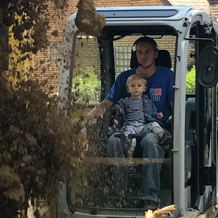 A man and a child are sitting in a vehicle that says ' ec ' on it