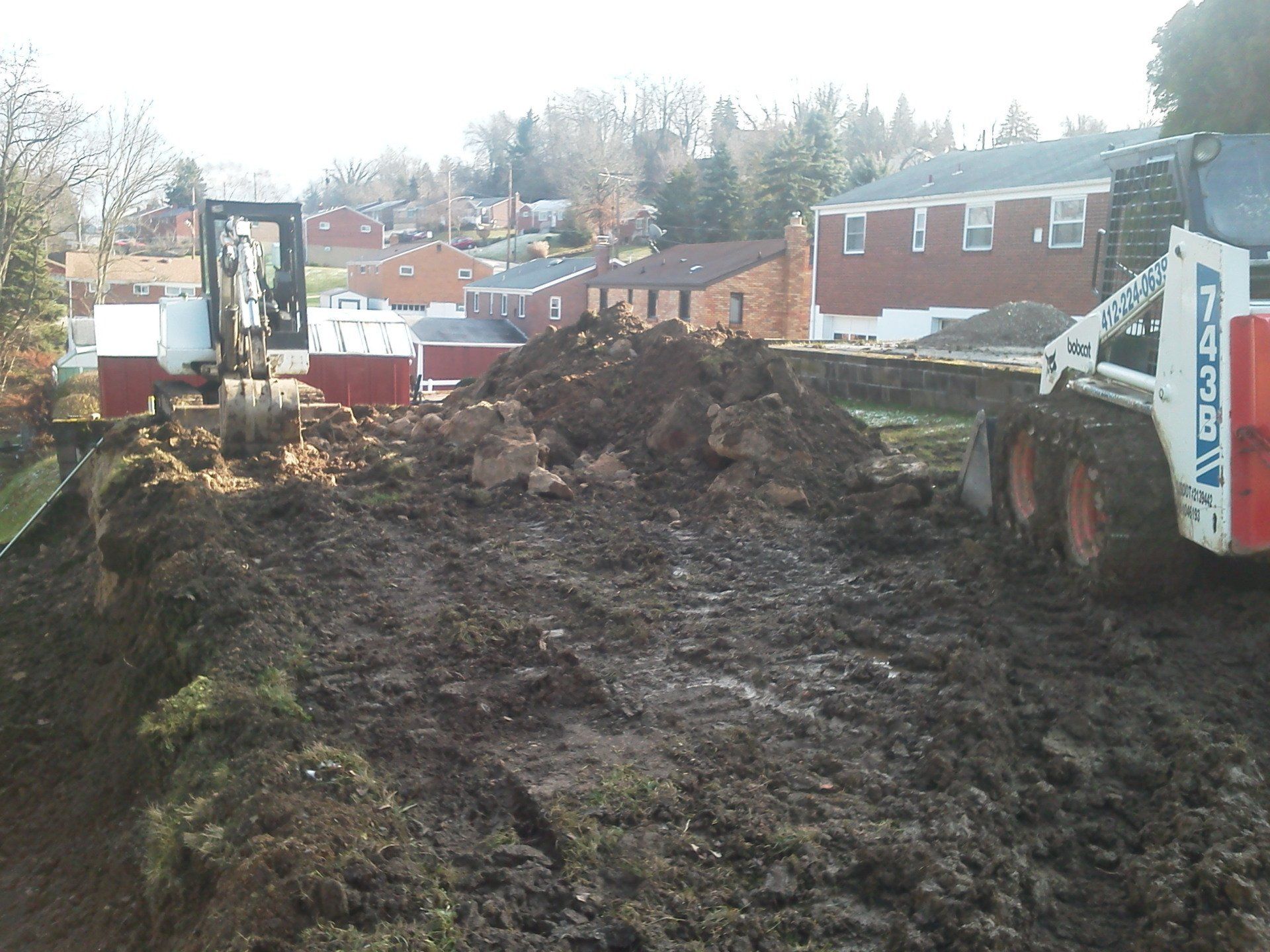 A bobcat is digging a hole in the dirt