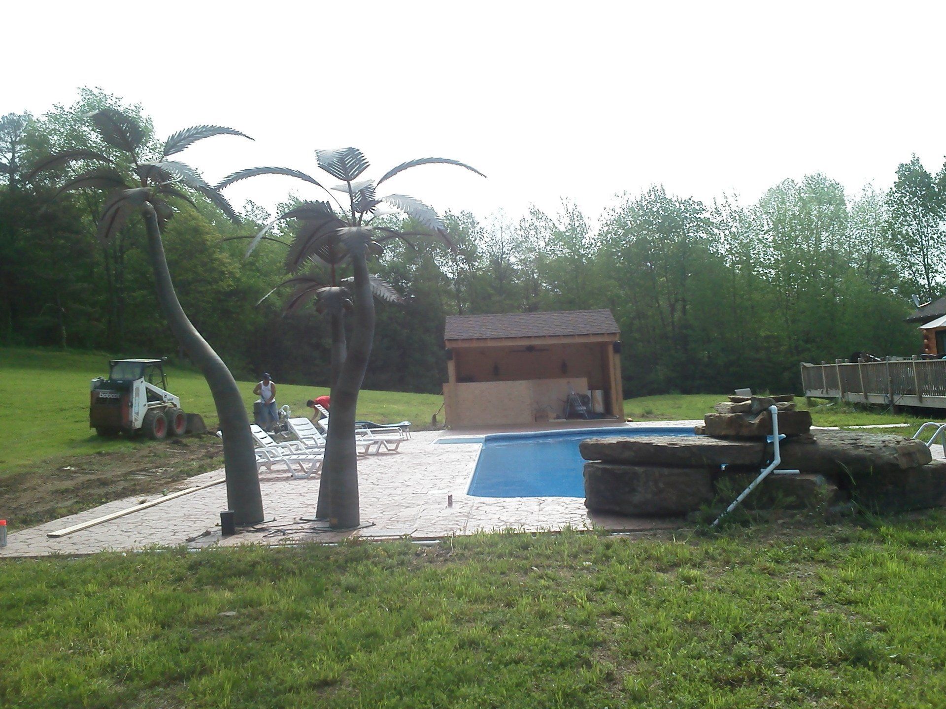 A large swimming pool with a gazebo in the background