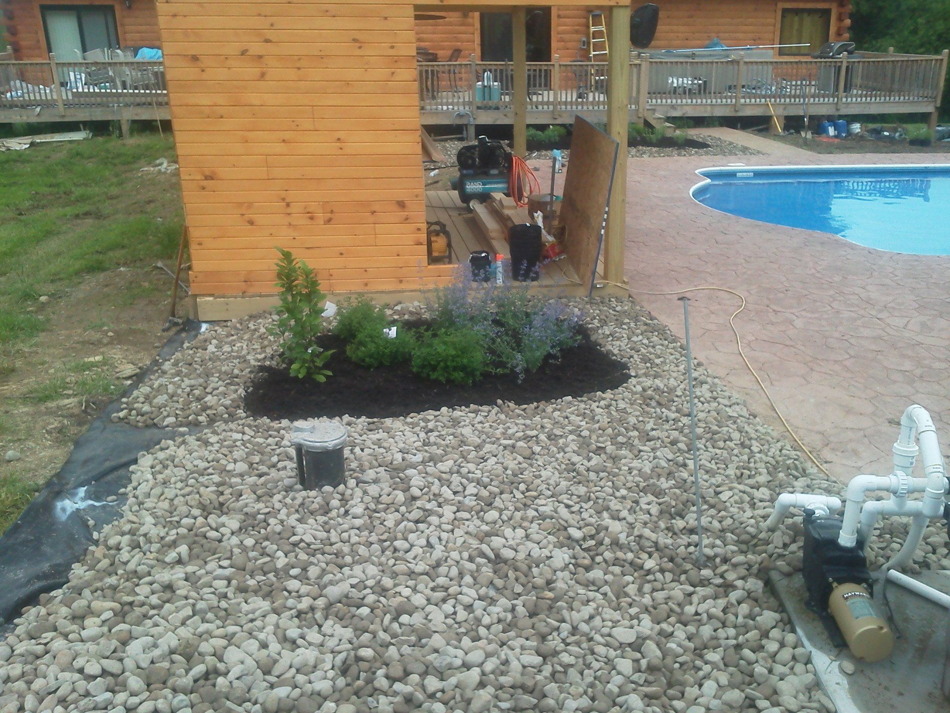 A wooden shed sits next to a swimming pool