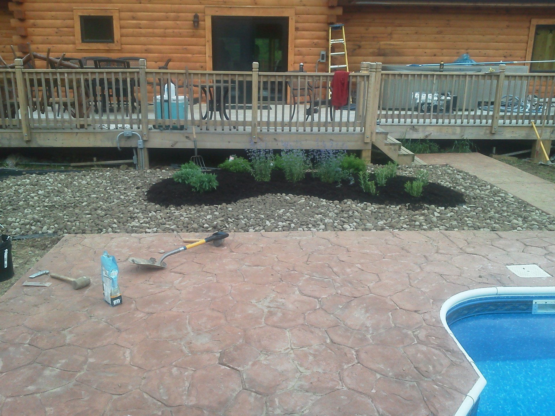 A patio with a pool in front of a log cabin