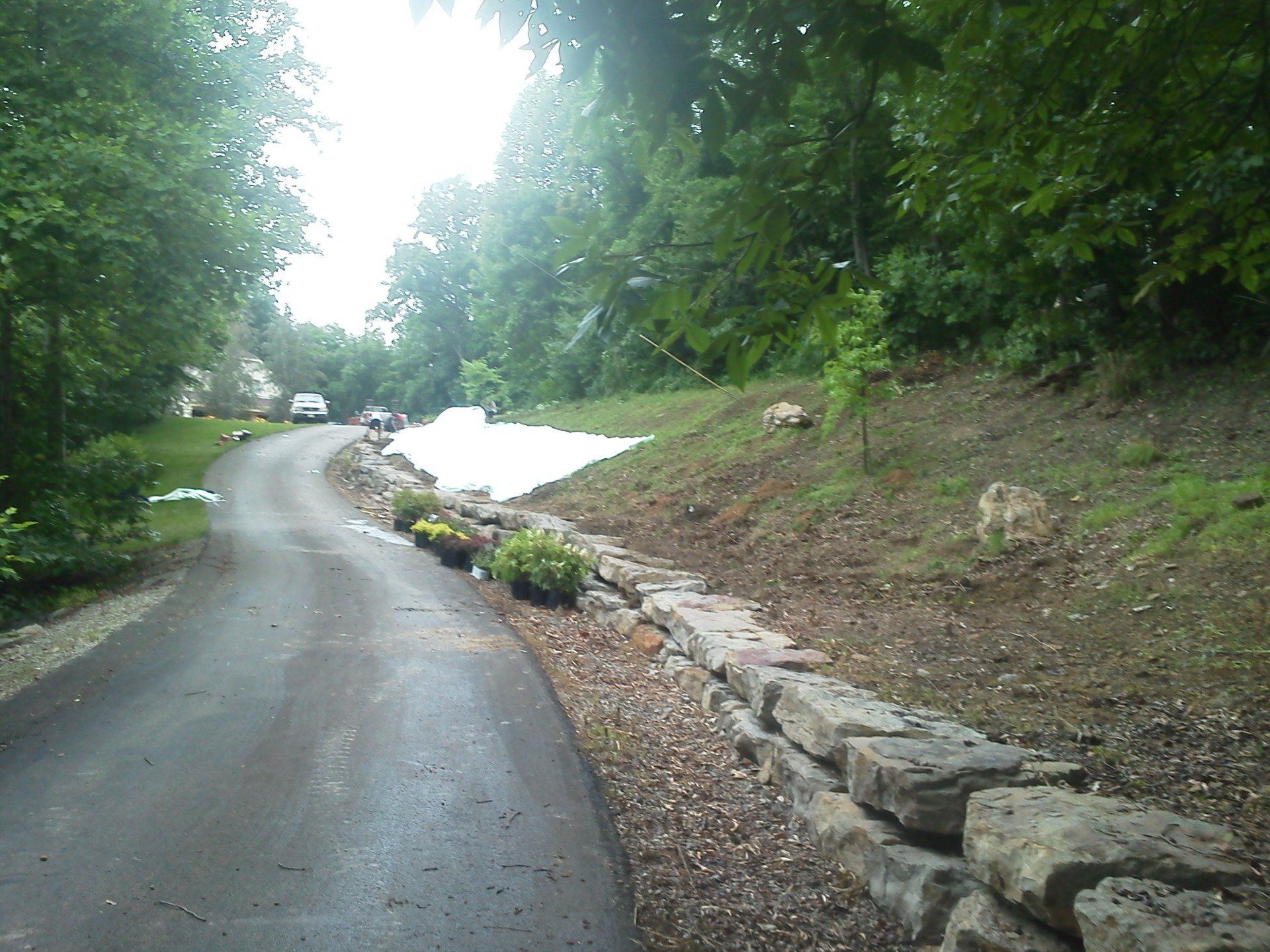 A road with a stone wall on the side of it