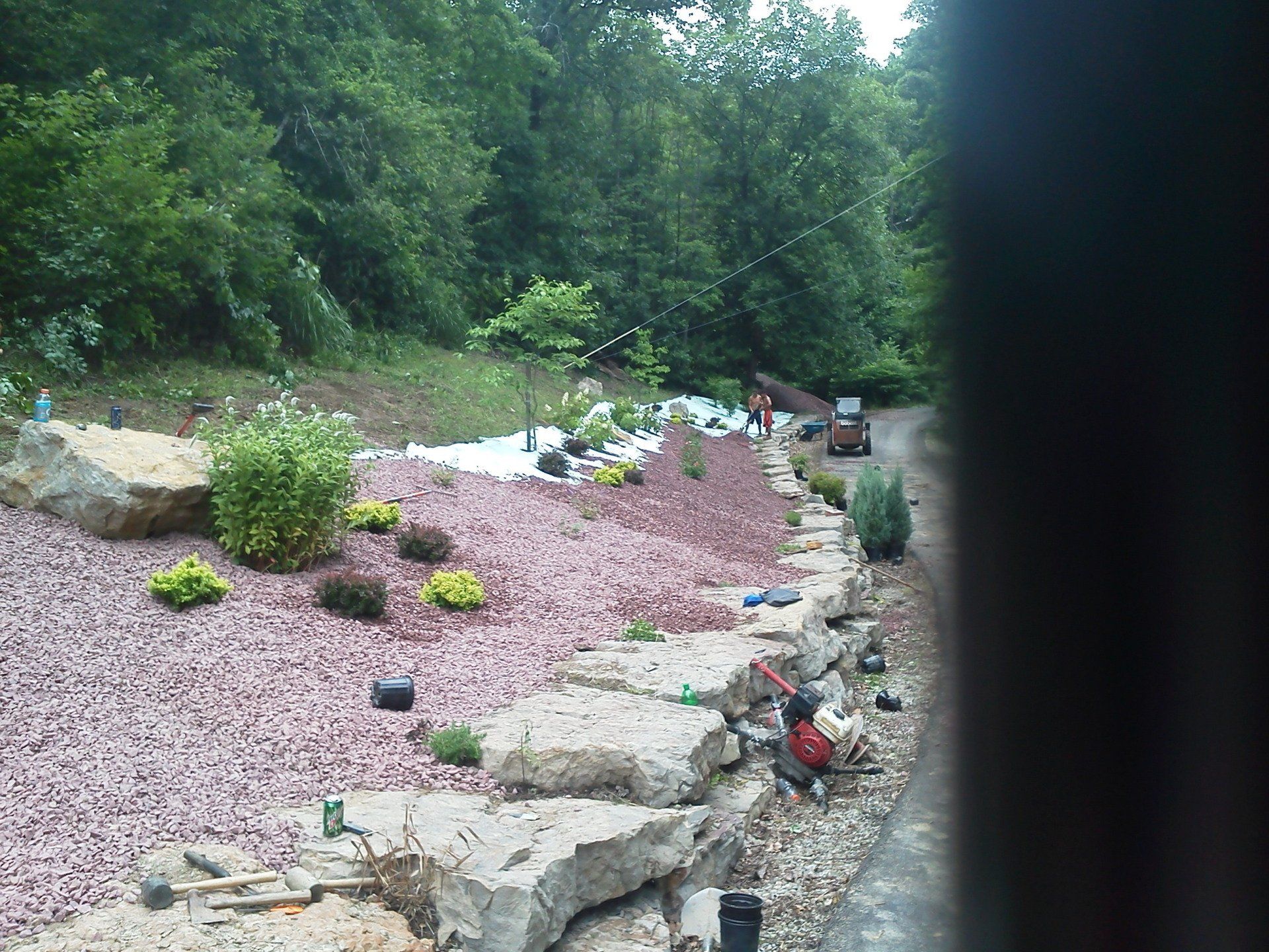 A landscape with rocks and gravel and trees in the background