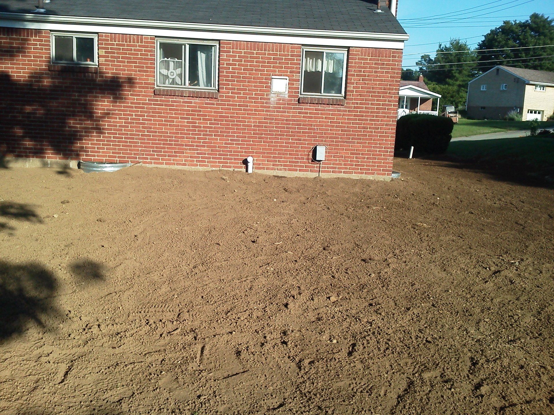 A brick house with a lot of dirt in front of it
