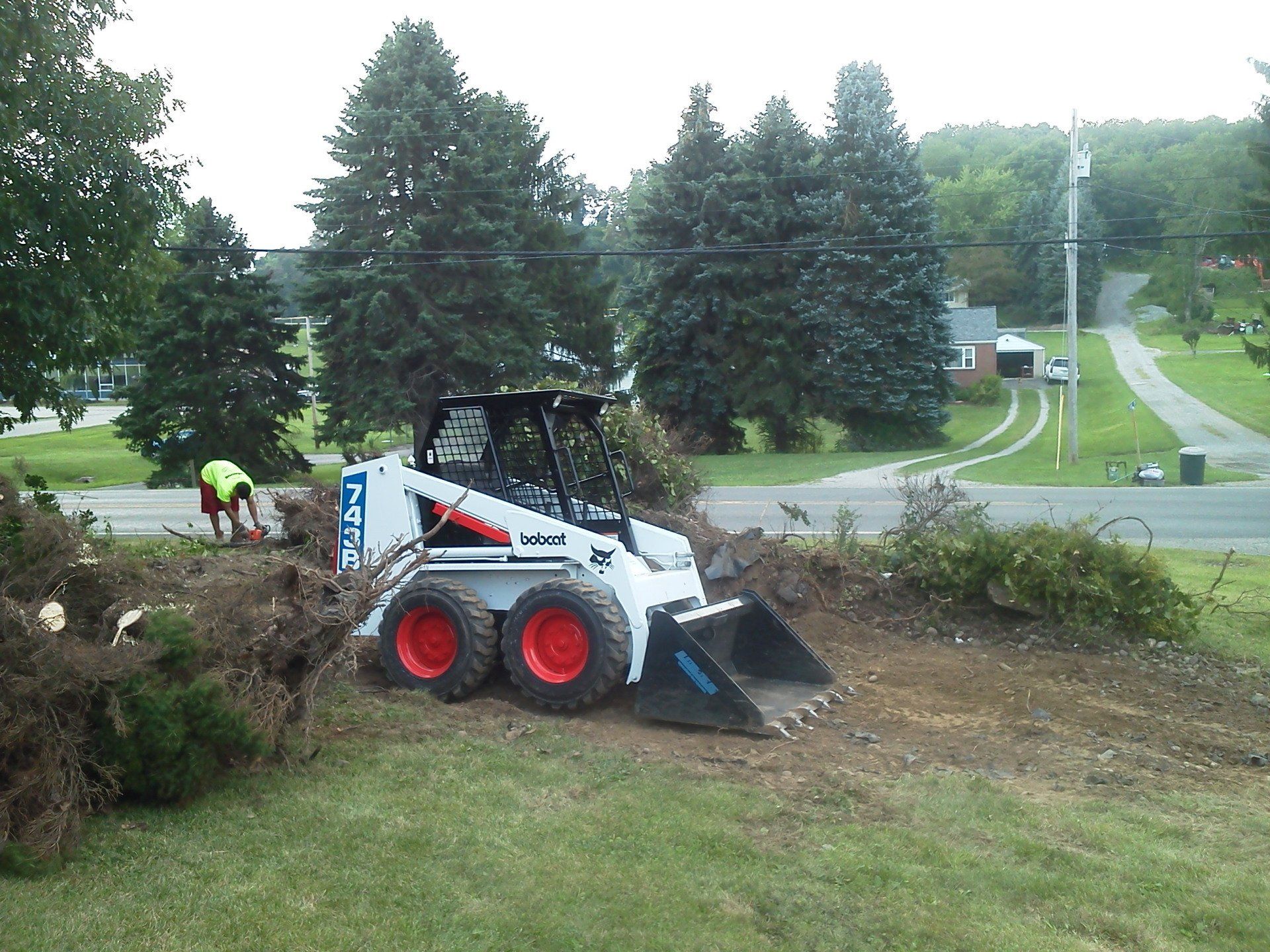 A bobcat skid steer is parked in a grassy area