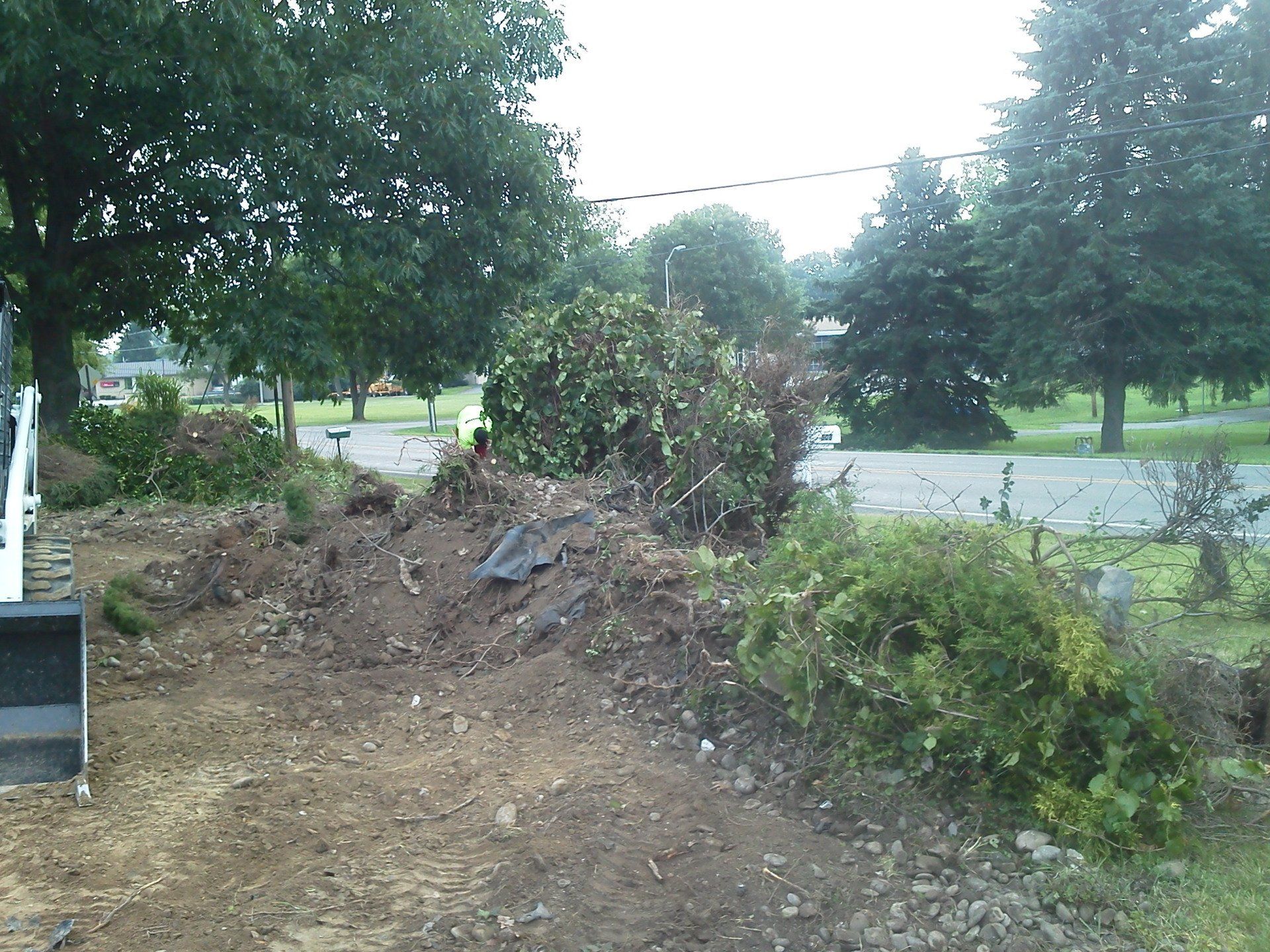 A large pile of dirt is in the middle of a yard