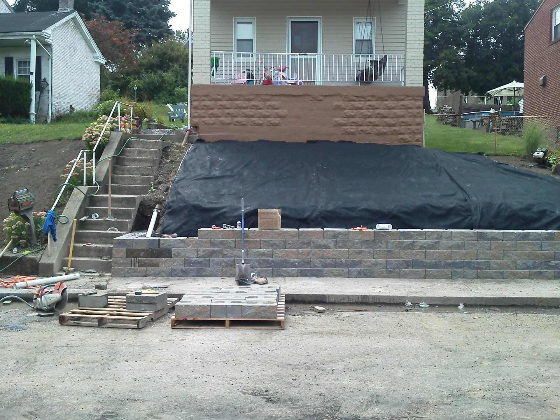 A house that is being built with a black tarp on the ground