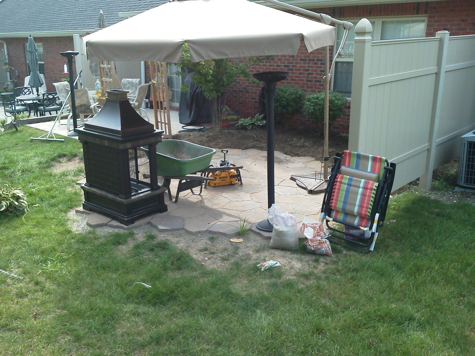 A patio area with a white umbrella and a chair