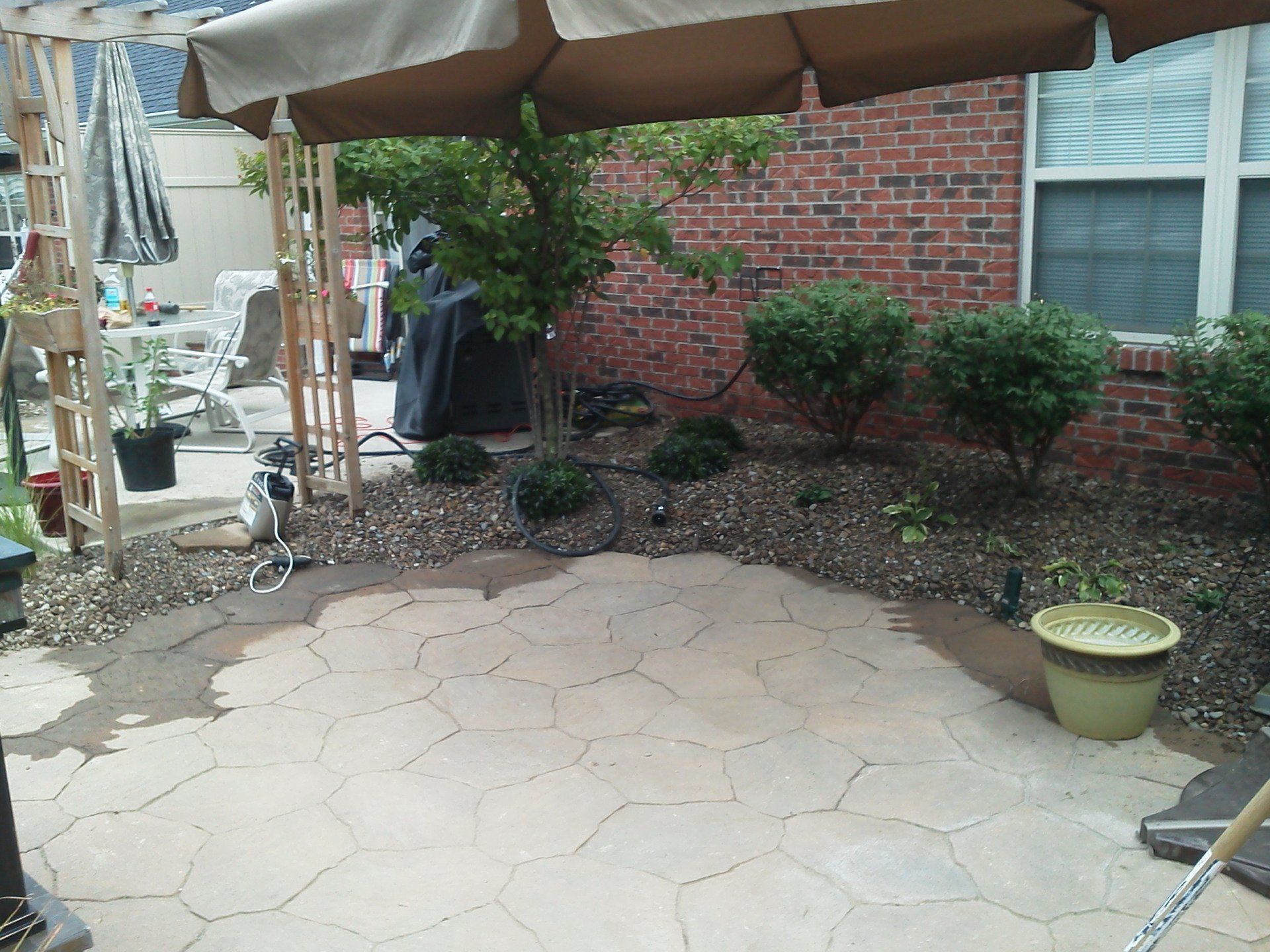 A patio with an umbrella and a potted plant