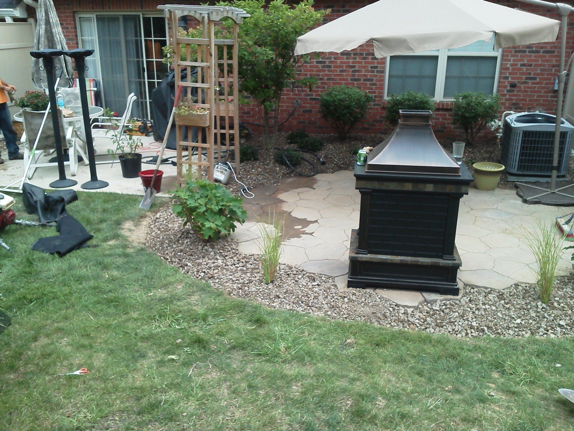 A backyard with a fire pit and umbrella