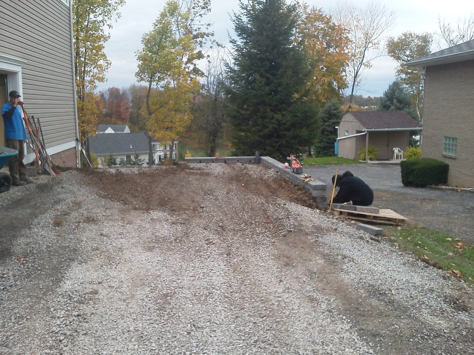 A large pile of gravel is in front of a house