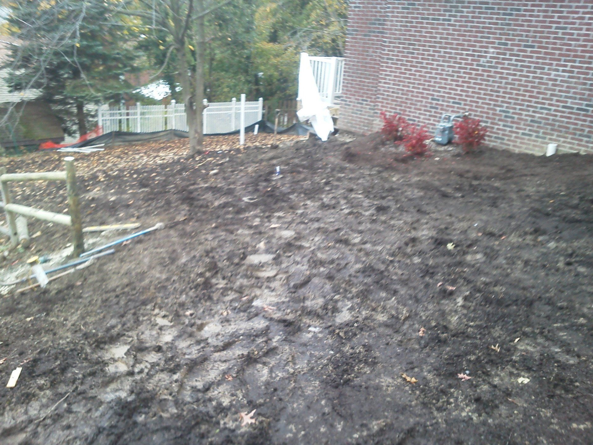 A large pile of dirt in front of a brick house