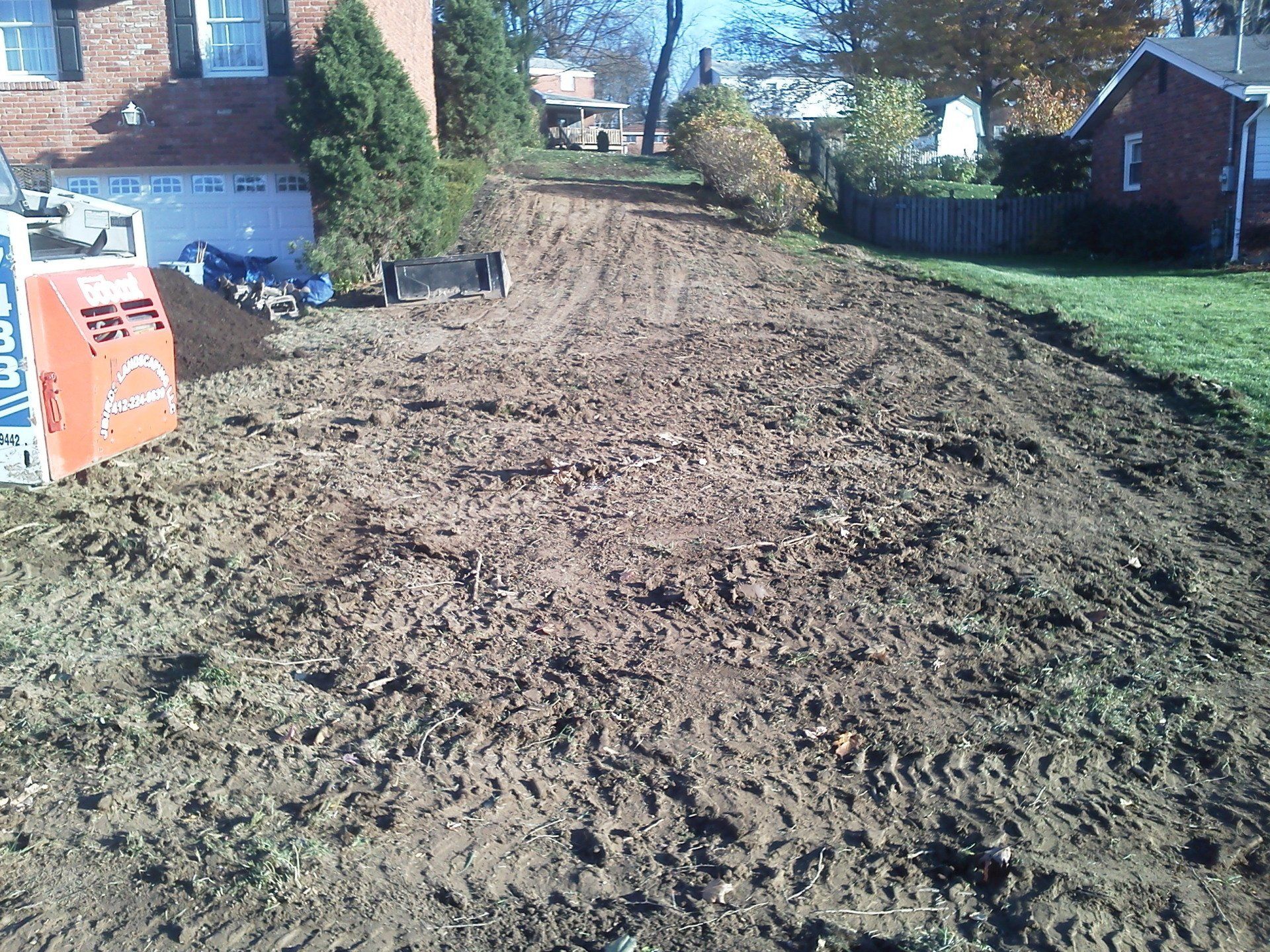 A dirt road with a house in the background