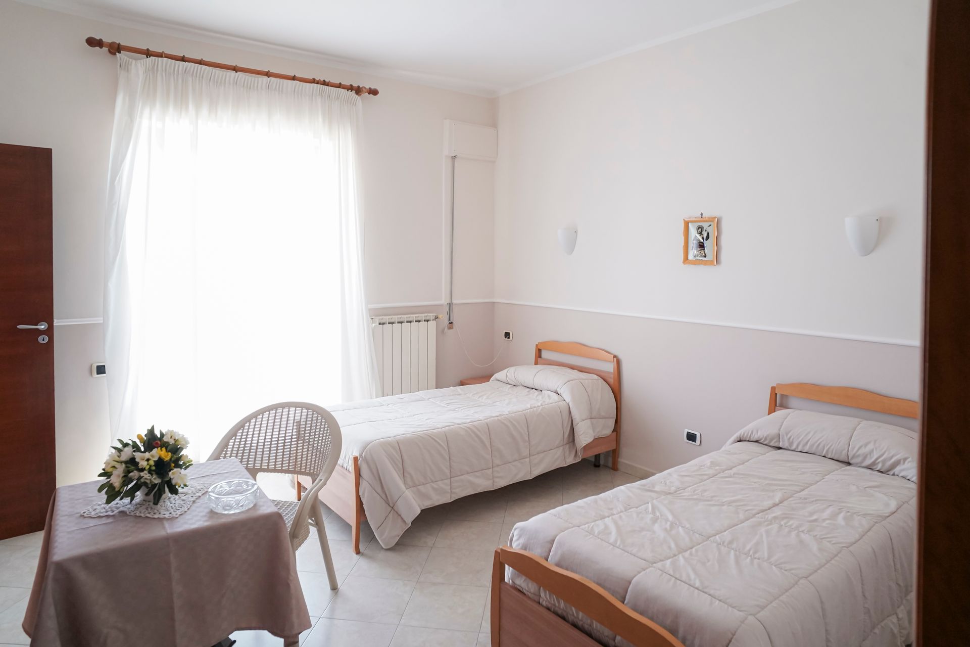 Due letti e una sedia in una stanza con quadri sul muro