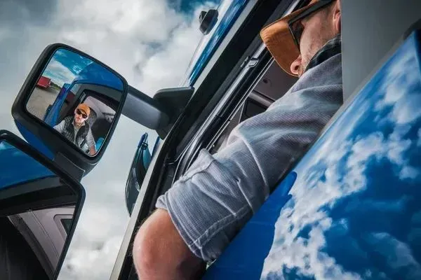A man is sleeping in the driver 's seat of a truck.