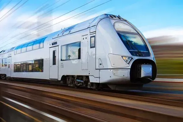 A white train is going down the tracks at high speed.