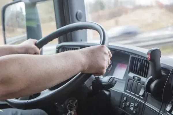 A man is driving a truck on a highway.
