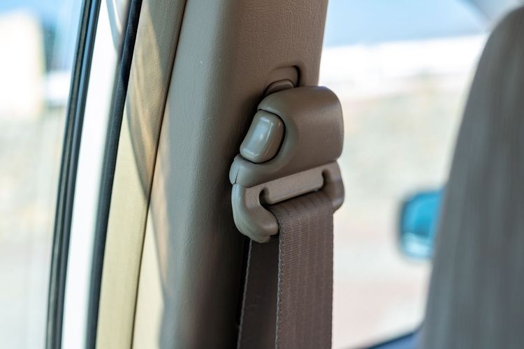 Close-up of a black car seat belt with red stitching and a silver buckle clasp Close-up of a black car seat belt with red stitching and a silver buckle clasp