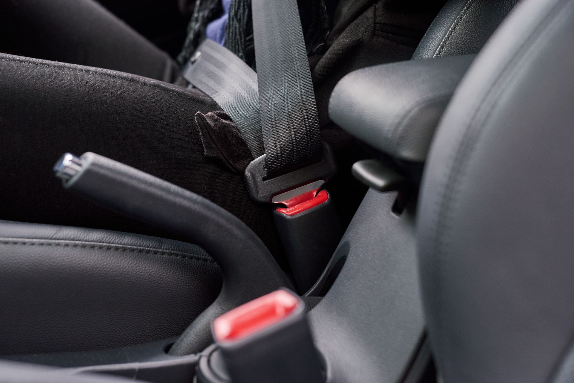 Car seat interior with two visible seat belt buckles and black upholstery Car seat interior with two visible seat belt buckles and black upholstery