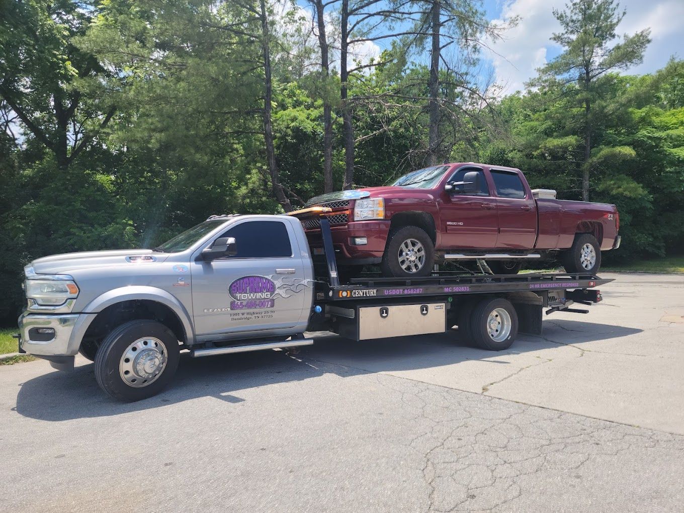 Two trucks are being towed by a tow truck.