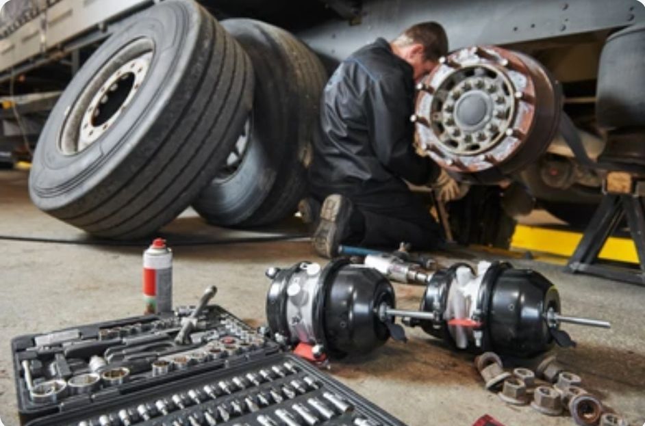 A man is working on a truck in a garage.