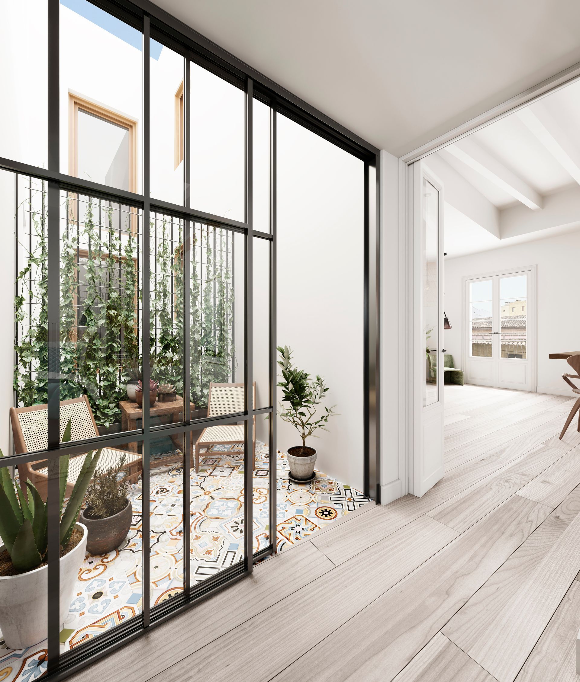 Pasillo luminoso con puertas de cristal con marcos negros que dan a un pequeño patio lleno de plantas.