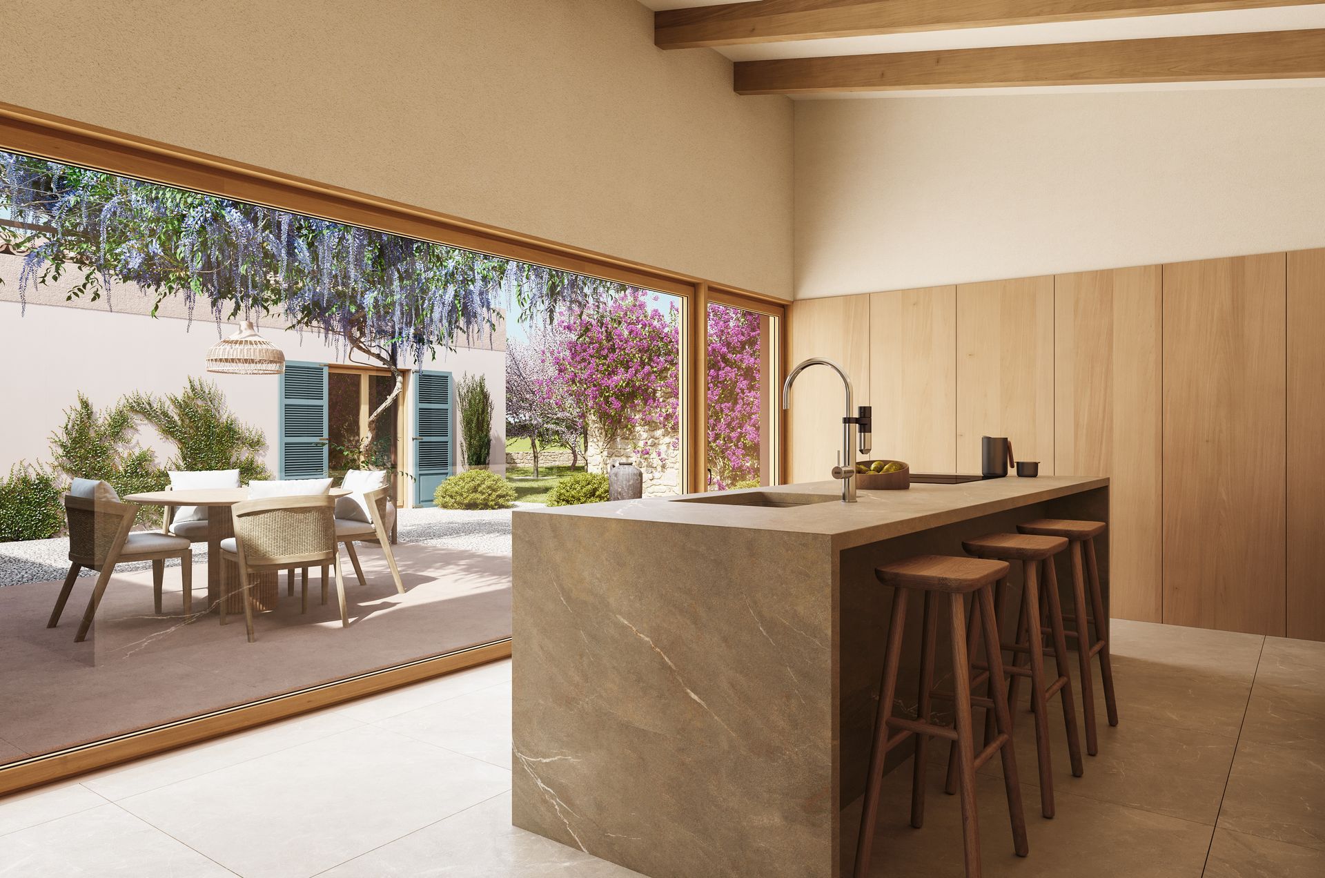 Cocina moderna con isla de mármol y taburetes, con acceso a un soleado patio ajardinado.