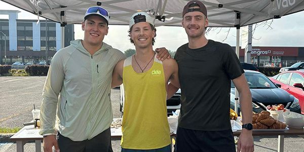 Three male participants pose at the event.