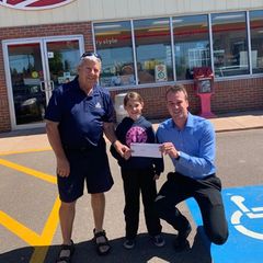 Ron and granddaughter Josie  holding up a donation cheque