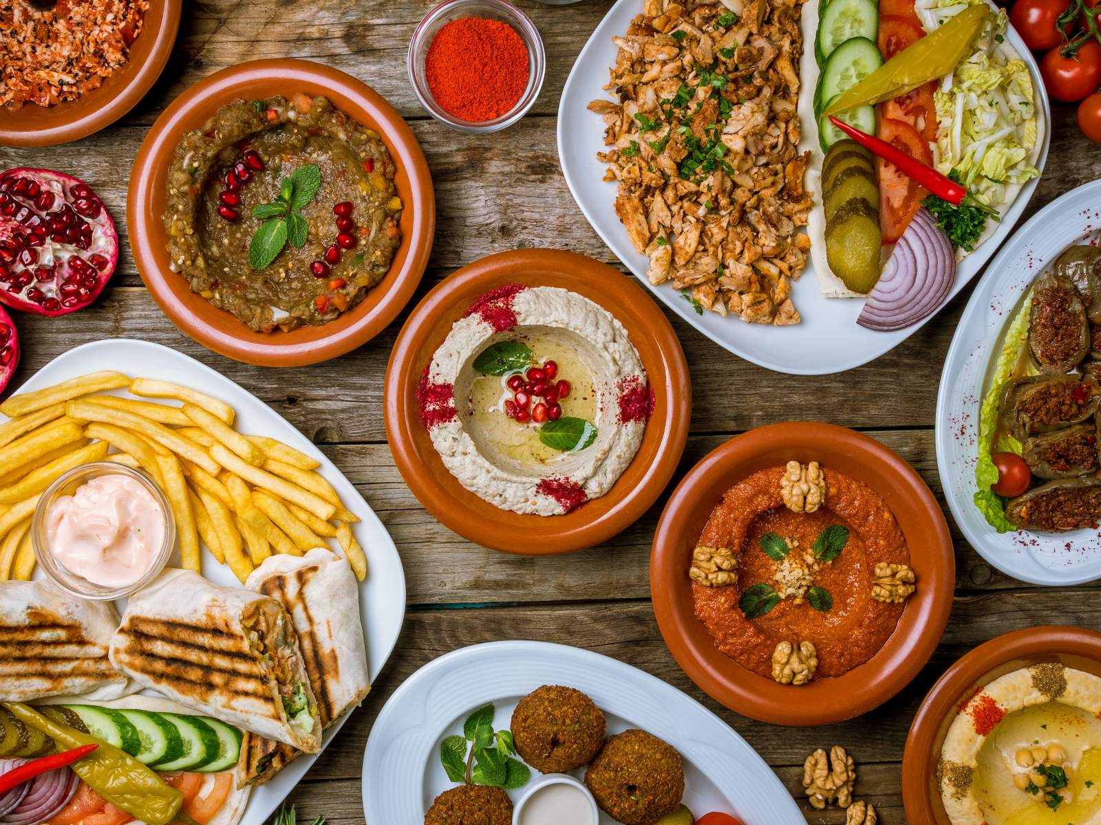 There are many different types of Middle Eastern food on the table.