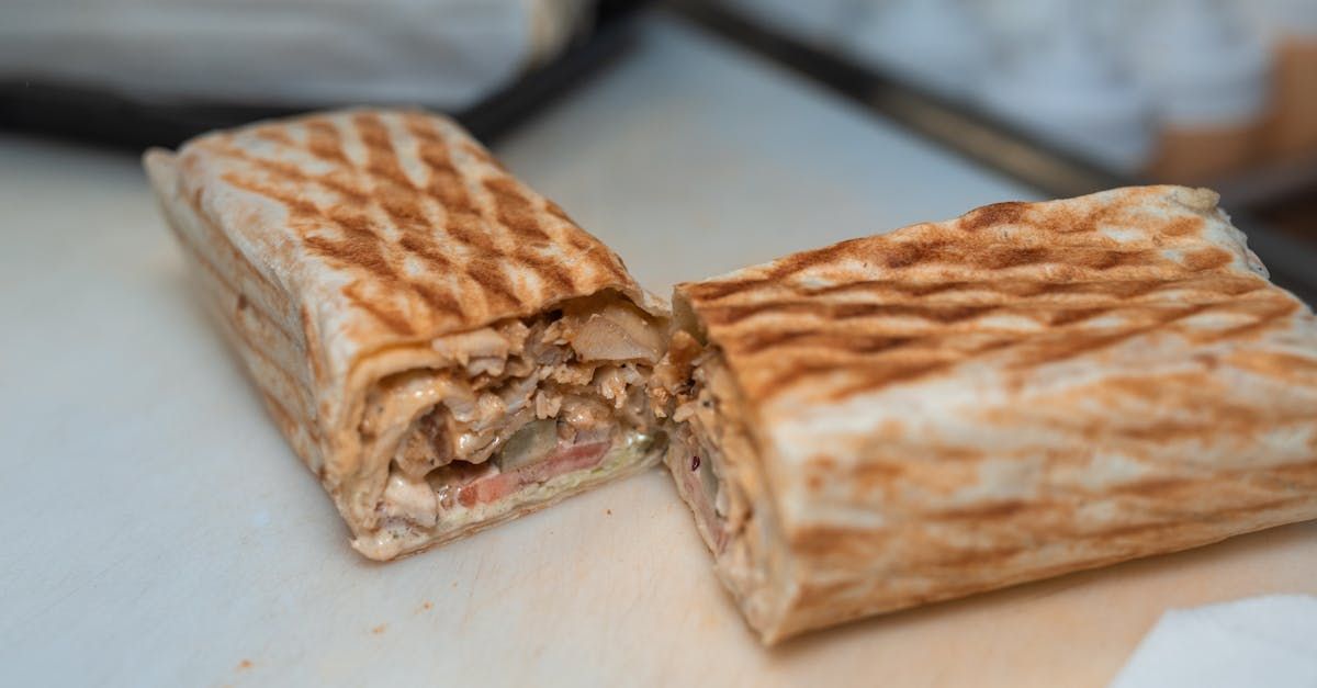 A close up of a sandwich that has been cut in half on a table.