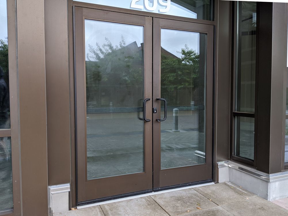 Glass double doors with brown trim at a storefront entrance