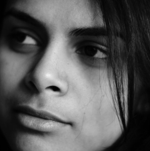 Close-up black-and-white portrait of a person looking to the side, with soft shadows on their face