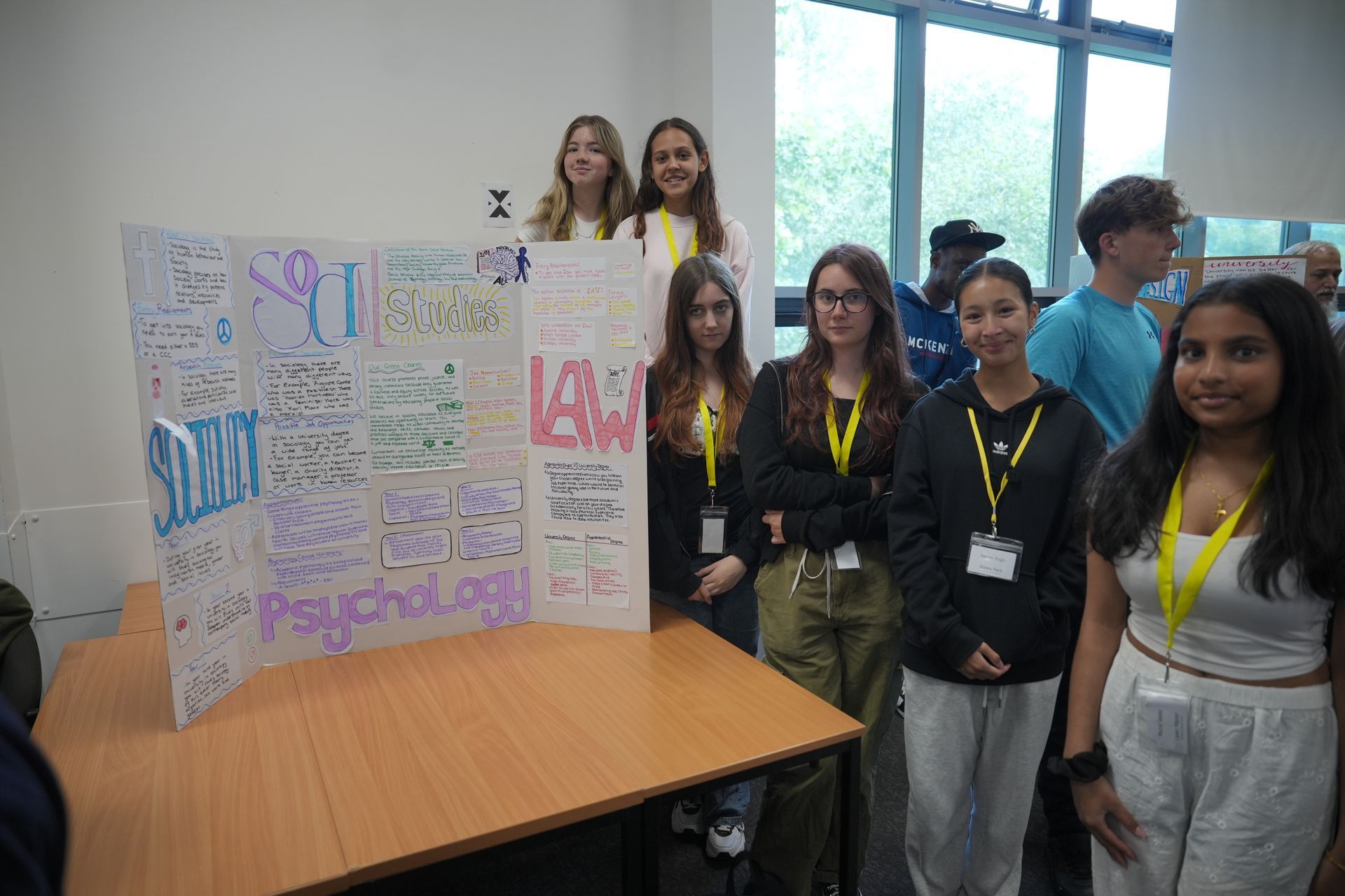 Students standing behind colorful poster boards at a school presentation booth