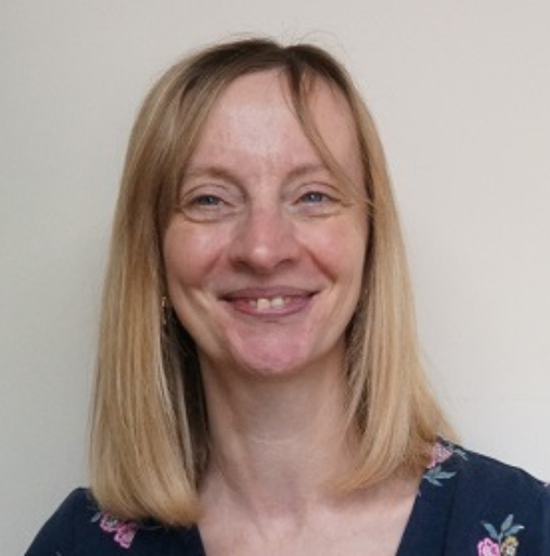 Smiling woman with shoulder-length blonde hair against a plain background