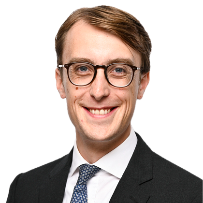Smiling man in glasses and suit against a white background