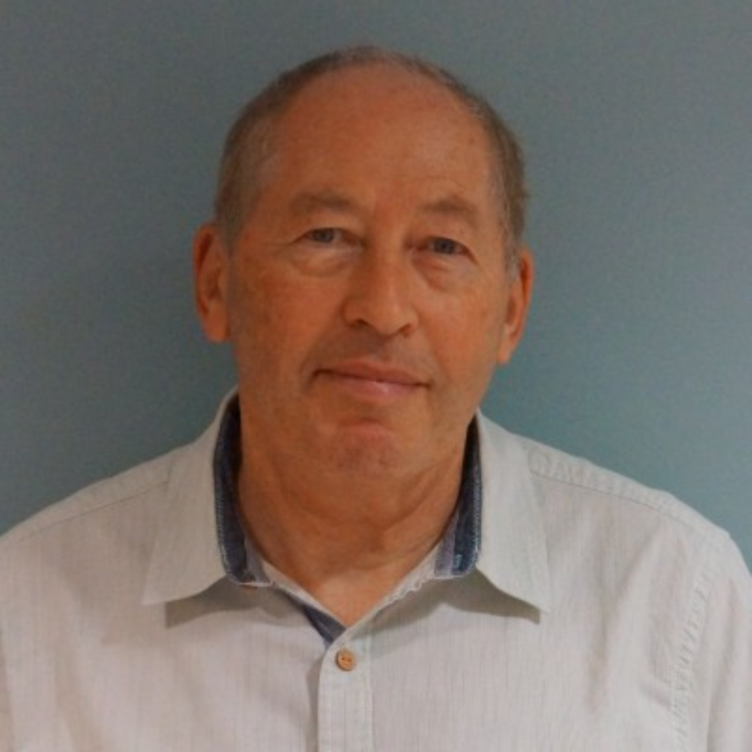 Portrait of a man in a light shirt against a plain blue-gray background