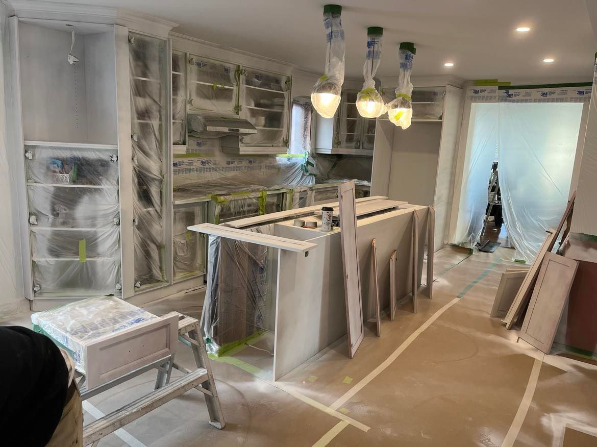 A kitchen is being remodeled with white cabinets and a large island.
