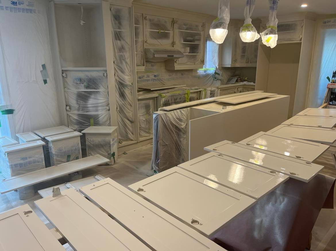 A kitchen with a lot of cabinets being painted white.