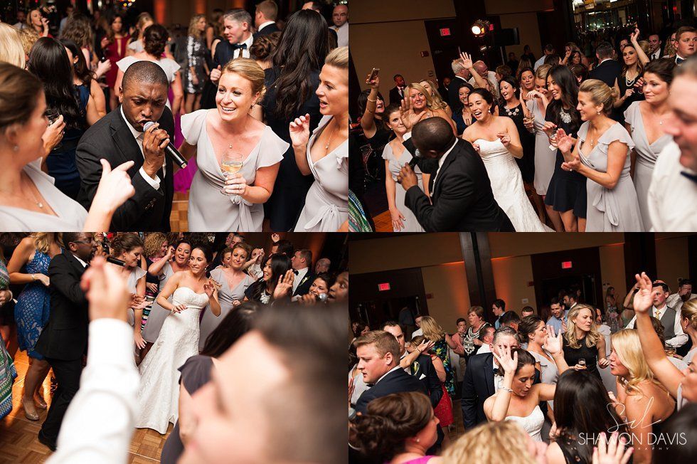 Guests dancing and cheering at a lively indoor wedding reception