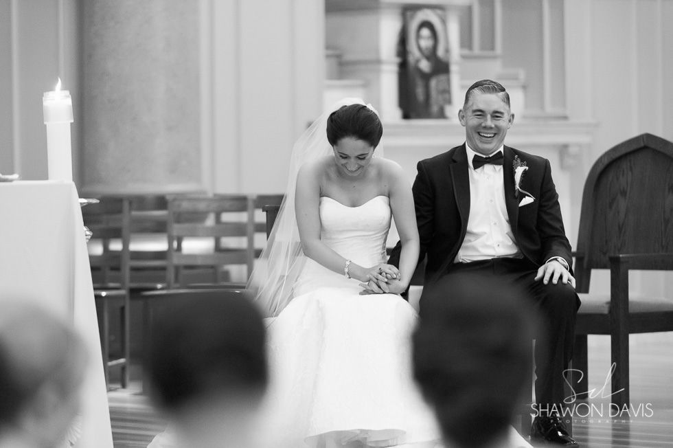 Bride and groom seated at the altar, smiling during a wedding ceremony