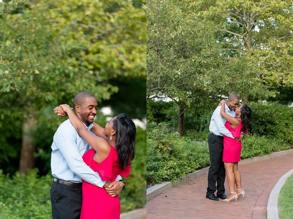 Couple embracing on a park path, with lush green trees in the background.