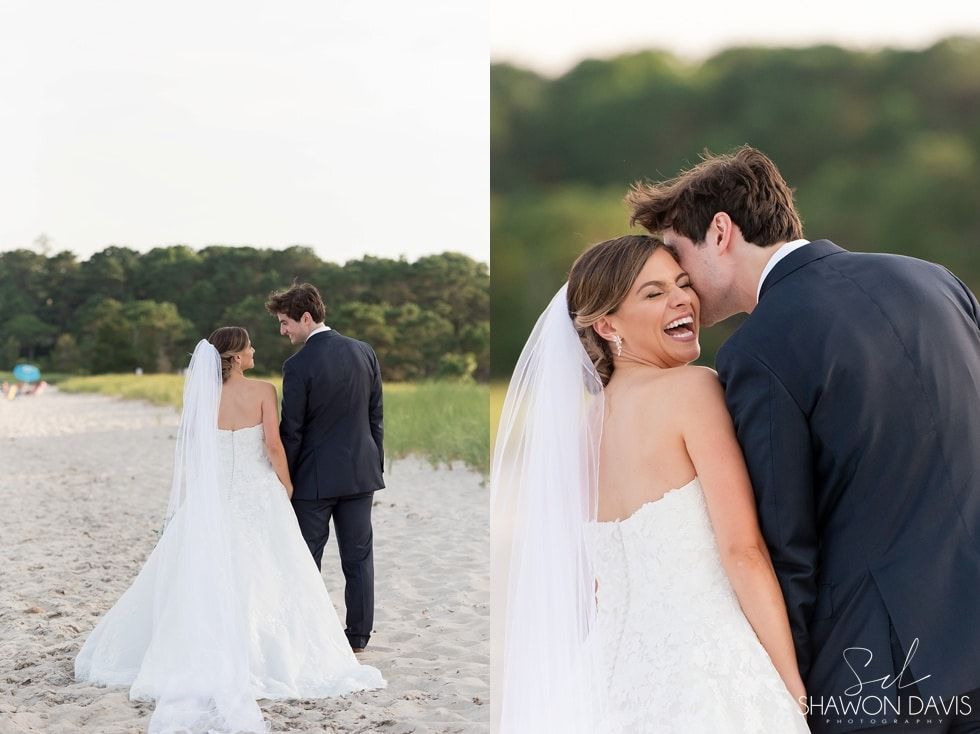 Bride and groom walking on a beach, smiling as she looks back toward the camera