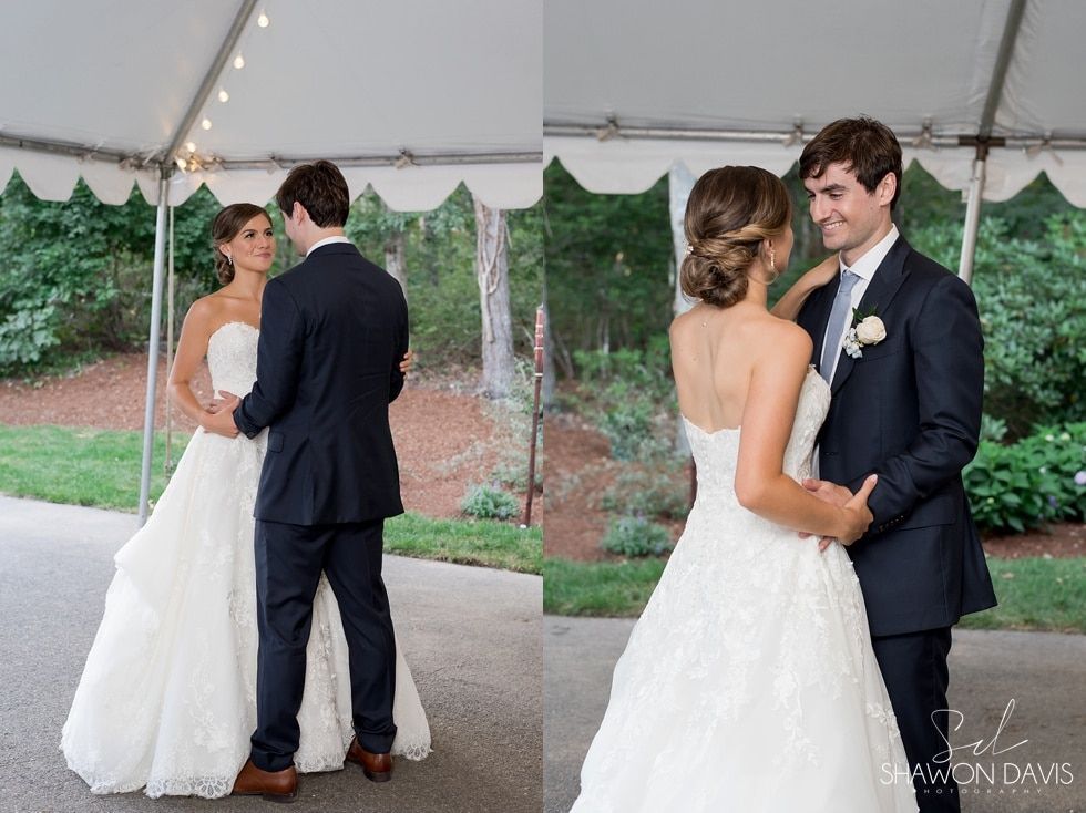 Two brides and two grooms share first looks under a white tent at an outdoor wedding.