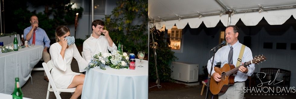 Wedding reception with bride and groom at a white table, and a guitarist performing under a tent.